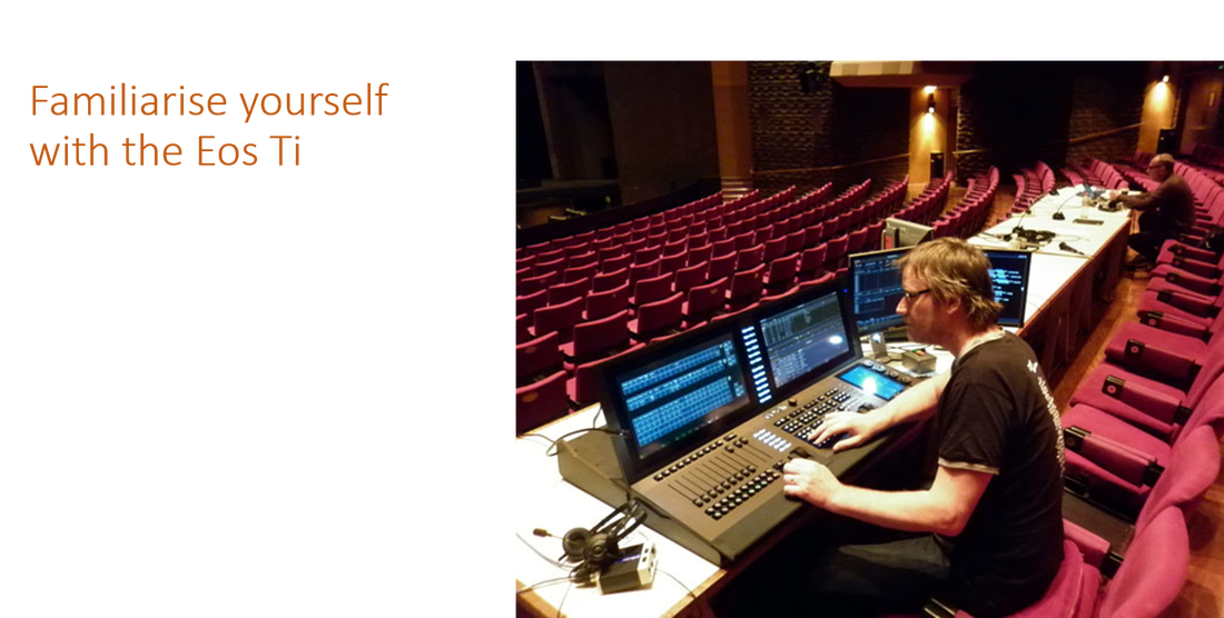 An a theatre with many seats, a sound engineer sits in front of a sound mixing machine with many buttons and 4 monitors.