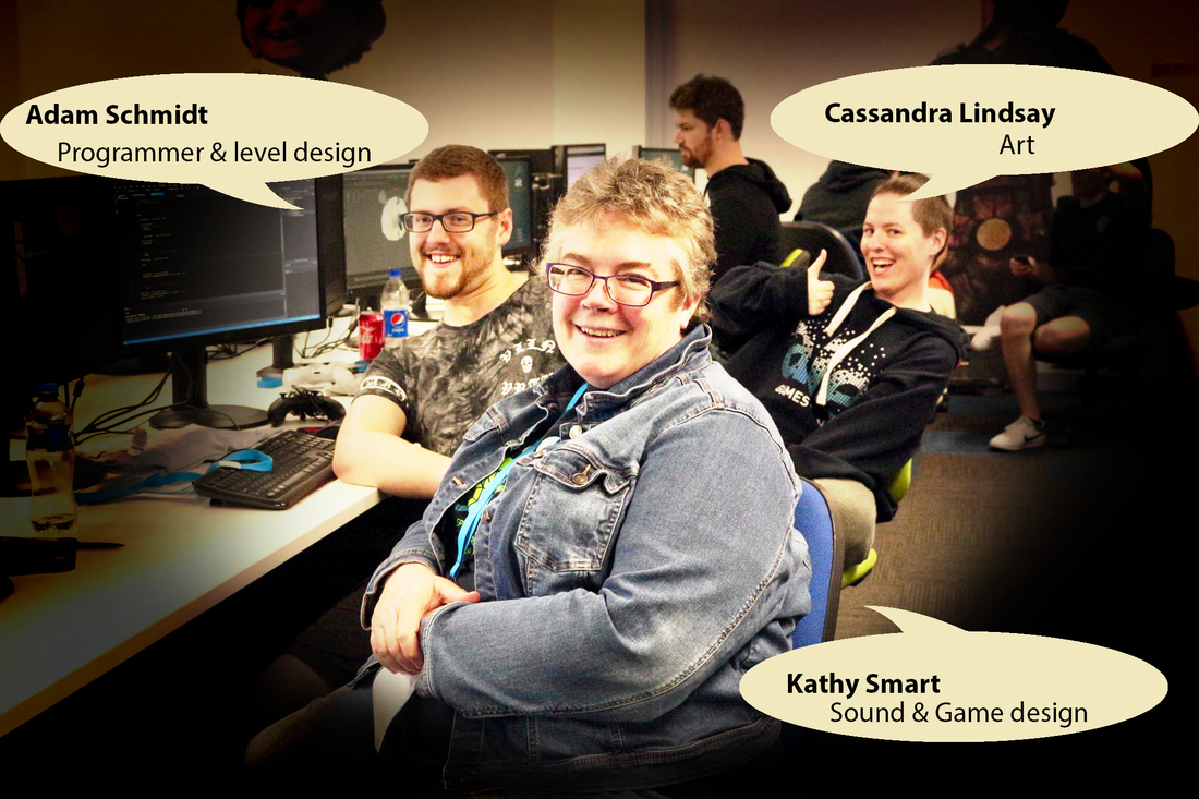 In a room filled with people in front of computers, 3 people sit at the front and have speech balloons.  Adam Schmidt, Programmer and level design; Cassandra Lindsay, Art; Kathy Smart, Sound and game design.